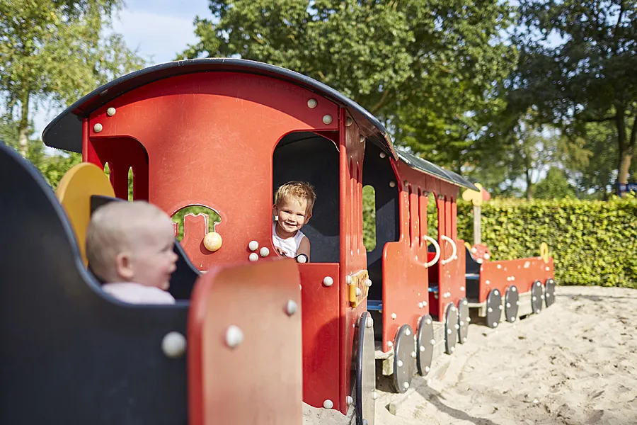 kinderen spelen op het treintje in de speeltuin