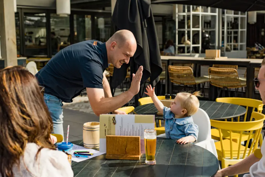 baby geeft high-five op terras van de wijde blick